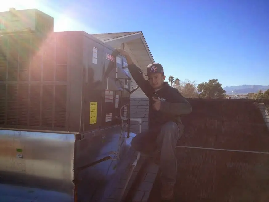 HVAC technician performing HVAC Inspection on a rooftop unit in Center Point